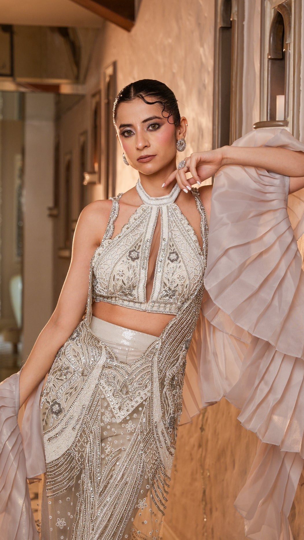 Woman in a glamorous outfit with intricate detailing in an elegant interior setting