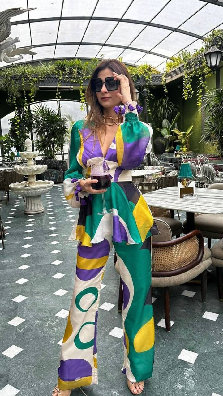 Woman in a colorful outfit standing in an outdoor cafe setting